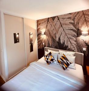 una camera da letto con un grande letto bianco con cuscini di Ryan Homes - in Apart hotel, La Défense a Courbevoie