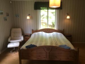 1 dormitorio con 1 cama, 1 silla y 1 ventana en Route 26 en Laxtjärn
