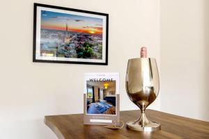 a book and a wine glass on a table at Luxury 5 Bed house in the City, includes parking & EV point in Norwich