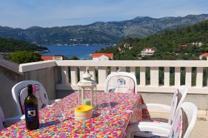una mesa con una botella de vino en el balcón en Apartments by the sea Cove Vrbovica, Korcula - 12057, en Korčula