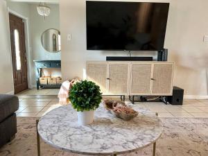 a living room with a table and a tv at Retreat on the Island in Merritt Island