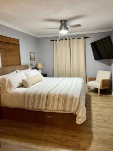 1 dormitorio con 1 cama grande y 1 silla en Retreat on the Island, en Merritt Island