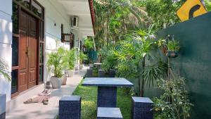 a patio with a blue table and potted plants at Ceylon Avenue in Habaraduwa