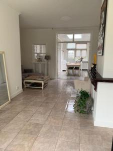 a living room with a large tiled floor and a living room at Een heerlijke woning op loopafstand van centrum! in Leeuwarden