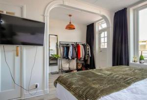 a bedroom with a bed and a flat screen tv at Een heerlijke woning op loopafstand van centrum! in Leeuwarden