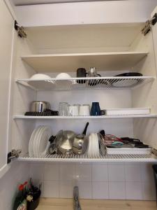 a kitchen pantry with plates and utensils on shelves at Beautiful studio - easy check-in, free parking & wifi in Rovaniemi +5 photos
