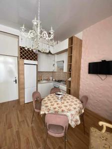une salle à manger avec une table, des chaises et un lustre dans l'établissement My sweet home in Rustavi city 1, à Roustavi