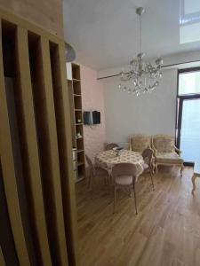 une salle à manger avec une table, des chaises et un lustre dans l'établissement My sweet home in Rustavi city 1, à Roustavi
