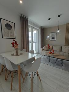 een woonkamer met een witte tafel en stoelen bij Apartament z 2 sypialniami - Nova Ludova - blisko 2 jezior in Biskupiec