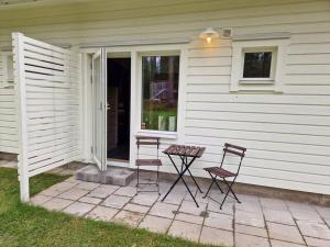 Övernattningsrum i separat gästhus på Sävastön في بودن: كرسيين وطاولة أمام المنزل