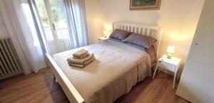 una camera da letto con un letto con asciugamani sopra di Villa Giardino Sa Tiacca a SantʼAndrea