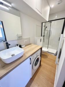 a bathroom with a sink and a washing machine at LE CARREAU DE FALGUIERE - Hypercentre - Gare in Toulouse