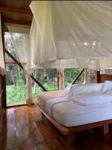 1 dormitorio con 1 cama con dosel en Hacienda Herrera Tambopata, en Puerto Maldonado