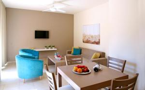 a dining room and living room with a table and chairs at Makronisos Village in Ayia Napa