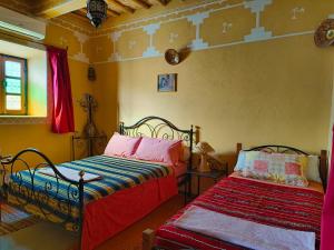 een slaapkamer met 2 bedden in een kamer bij Kasbah Imini Restaurant & Hotel in Taourirt