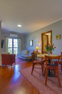 een woonkamer met een tafel en stoelen en een bank bij Hotel Palazzo Reale in Campos do Jordão