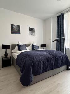 um quarto com uma cama grande e um edredão azul em Gemütliche 2-Zimmer Wohnung - Zentral - Netflix em Wuppertal