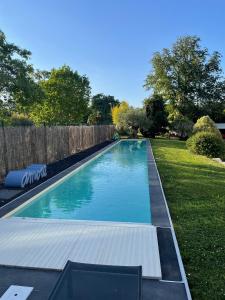 una piscina en un patio junto a una valla en Château Ollé Laprune, en Jurançon