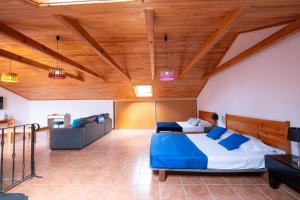 um quarto com 2 camas num quarto com tectos em madeira em Casa del Mar I by GALMI em Arco de São Jorge