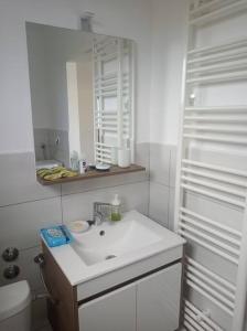 a white bathroom with a sink and a mirror at Lovely flat, city center with free parking in Varaždin