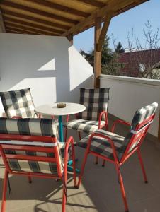 three chairs and a table on a patio at Lovely flat, city center with free parking in Varaždin