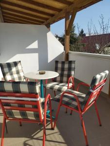 three chairs and a table on a patio at Lovely flat, city center with free parking in Varaždin +8 photos