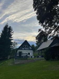 a large white barn with a gazebo in a field at Szmerkowa Chatynka z kominkiem i jacuzzi w Karkonoszach in Lubawka