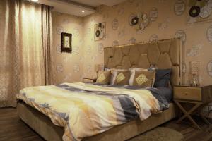 a bedroom with a bed in a room with wallpaper at Luxury 1 Bedroom Apartment Gold Crest Mall And Residency DHA in Lahore