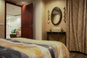 1 dormitorio con cama y espejo en la pared en Luxury 1 Bedroom Apartment Gold Crest Mall And Residency DHA, en Lahore