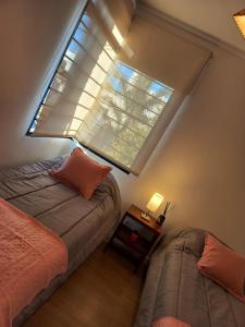 een slaapkamer met 2 bedden en een groot raam bij La Josefina in Tandil