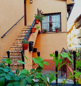 ATALAYA DEL RÍO في فالديروبريس: منزل مع نباتات الفخار على الدرج
