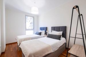 1 dormitorio con 2 camas y escalera en Wings Apartment CE by GALMI, en Santa Cruz