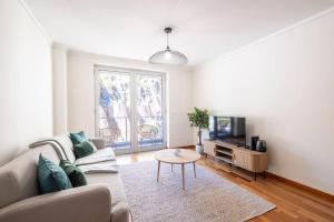 Una sala de estar con un sofá, un televisor y una mesa. en Wings Apartment CE by GALMI, en Santa Cruz