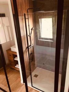 a shower with a glass door in a bathroom at Maisonnette avec terrasse in Argences