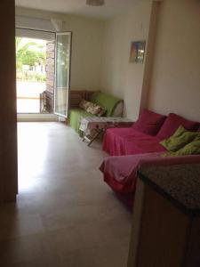 un soggiorno con due letti e un divano di coqueto y acogedor apartamento a Isla Cristina