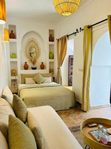 1 dormitorio con 2 camas, sofá y mesa en Riad Dar Elma And Spa, en Marrakech