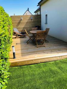 a wooden deck with a table and chairs on it at Maisonnette avec terrasse in Argences