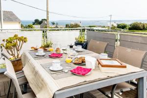 una mesa con comida y bebida en el balcón en Chambre d'Hôtes de la Grande Greve en Roscoff