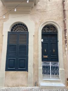 zwei Türen an der Seite eines Gebäudes in der Unterkunft Birgu No 25 apartment 3 in Vittoriosa