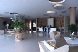 a lobby with white furniture and people in the background at Hermoso y lujoso piso 14 con Salida Directa a la playa y clubhouse increible in Santa Marta +96 photos