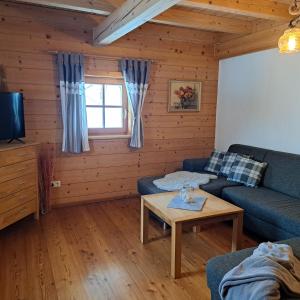 ein Wohnzimmer mit einem Sofa und einem Tisch in der Unterkunft Ferienwohnung Familie Sigl - Rotlechner in Sankt Peter am Kammersberg