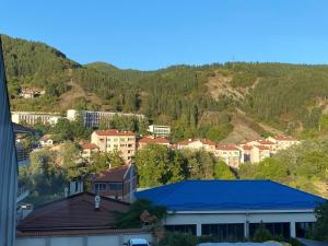 a town with a blue roof in front of a mountain at Eda Aparts in Devin