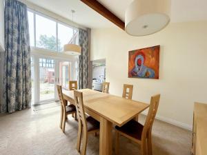 a dining room with a wooden table and chairs at 3 Chatsworth Road, Worsley in Manchester