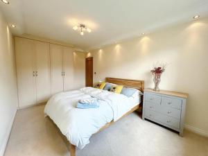 a bedroom with a bed and a dresser in it at 3 Chatsworth Road, Worsley in Manchester