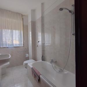 Antonelli apartments في نوفارا: حمام مع حوض استحمام ومرحاض ومغسلة