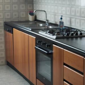 Antonelli apartments في نوفارا: مطبخ مع موقد ومغسلة