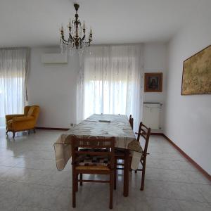 Antonelli apartments في نوفارا: غرفة طعام مع طاولة وكراسي وثريا +24 صورة