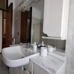 y baño con lavabo blanco y espejo. en Cantelli Antonelli, en Novara