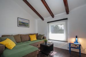 sala de estar con sofá y ventana en The Greens Family House en Zlatibor