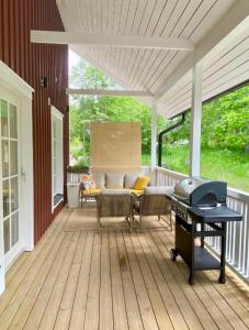 a screened porch with a bbq and a grill at Villa Tilda in Matildedal